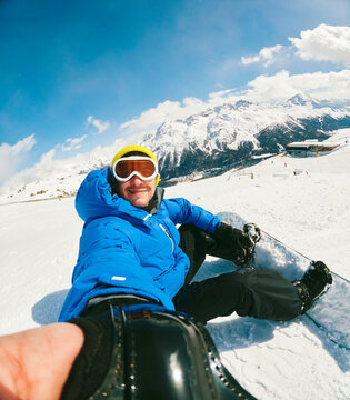 Man smiling and walking with his snowboard 