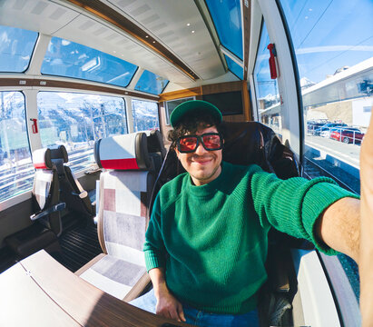Man taking a selfie in a train while traveling
