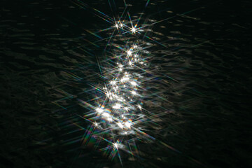 Sun reflection with stars on dark water