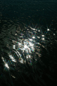 Sun reflection with stars on dark water