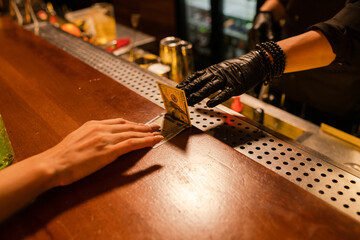 Payment for the cocktail in the bar at night 