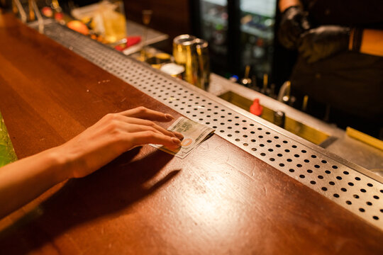 Body part with money in cocktail bar 