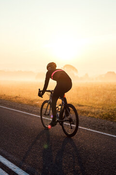 A cyclist rides along the road early in the morning