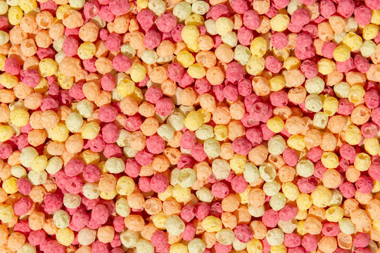 Colorful ball-shaped pop breakfast cereal on pink background