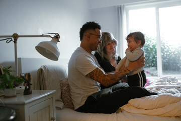 Family bonding time in a cozy bedroom setting