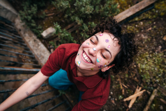 Smiling Gen Z woman with stickers on her face