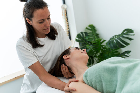 Physiotherapist assisting patient with neck exercise