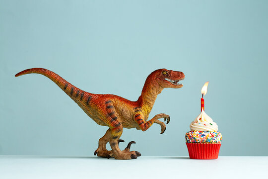 Fototapeta Dinosaur celebrating with a birthday cupcake