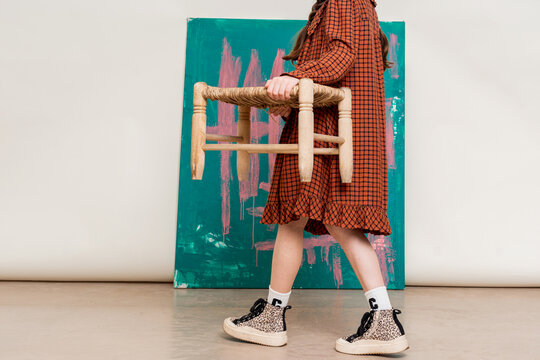 Girl with Wooden Stool and Abstract Painting