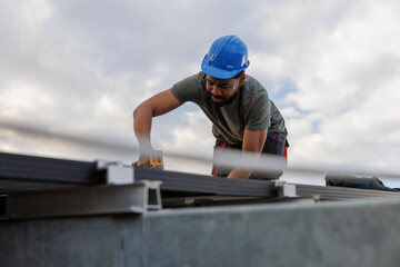 Technician installing solar panels on rooftop