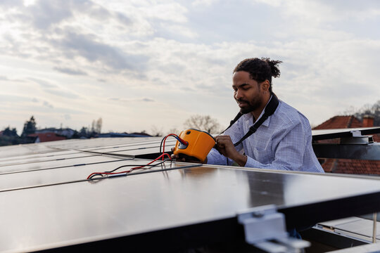 Engineer using equipment on photovoltaic modules