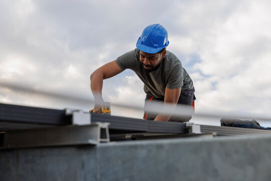 Technician installing solar panels on rooftop