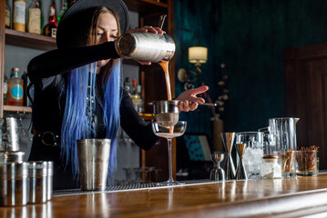 Bartender prepares cocktail at the bar counter