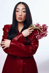 Stylish Asian Woman in Red Leather Jacket Holding Bouquet of Flowers, Fashion and Beauty Concept