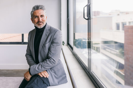 Confident businessman in a modern office setting - Powered by Adobe