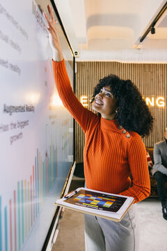 Casual businesswoman presenting on an interactive screen