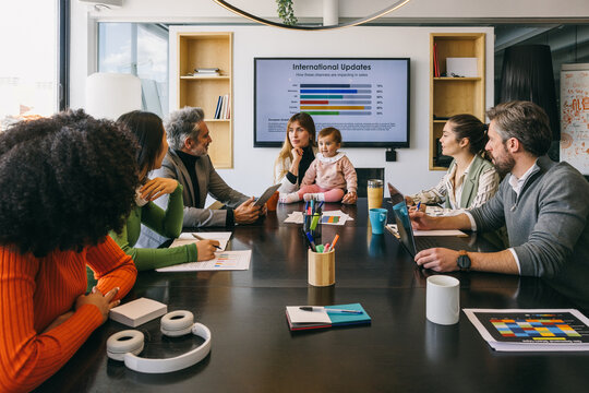 Diverse team in a business meeting with presentation - Powered by Adobe
