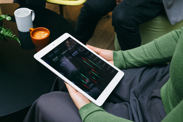 Casual market analysis with a tablet and coffee