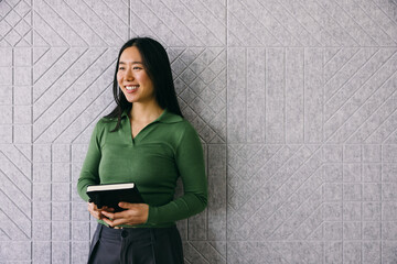 Asian professional with planner against textured backdrop