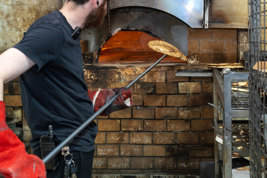 Matzah Removal from Oven for Passover. Jewish Baker Retrieving Matzah.