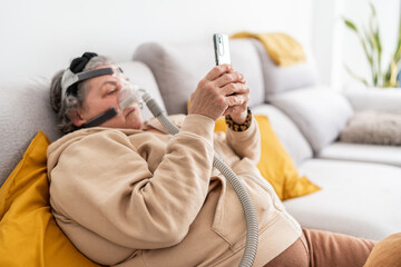 Woman with CPAP mask using smartphone.