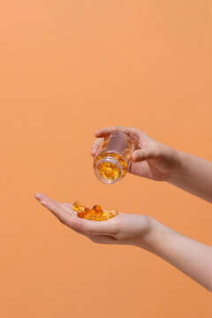 Left hand holding a transparent bottle cod liver oil omega 3