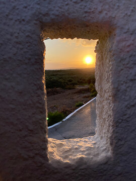 Amazing view of the sun through the hole in the white wall.