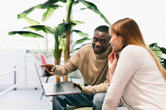 Coworkers Discussing a Project on a Laptop