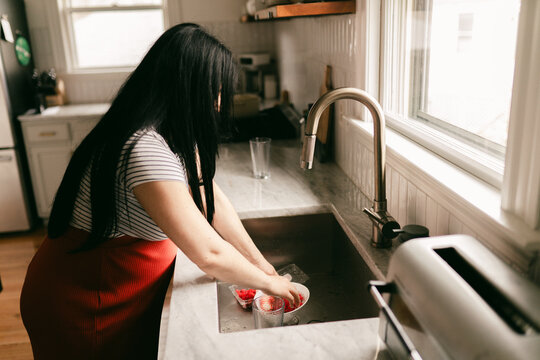pregnant mother washing strawberries  