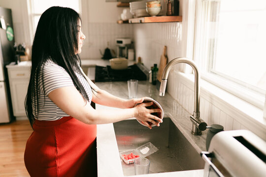 pregnant mother washing strawberries  