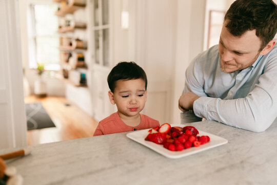 toddler son and dad eating a snack on berries  