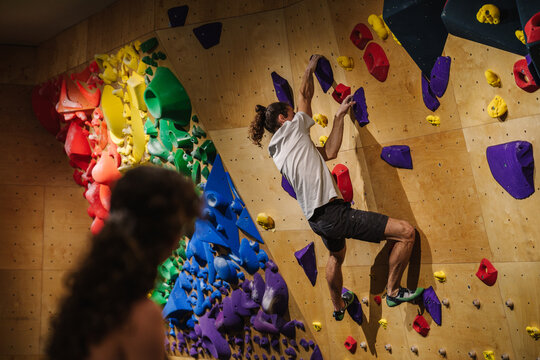 Couple of climbers bouldering in an overhang climbing wall