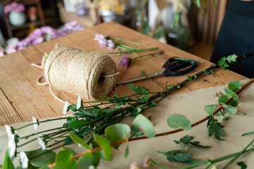 Florist's workspace with fresh cut flowers and twine