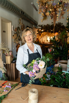 Flower shop owner holding bouquet