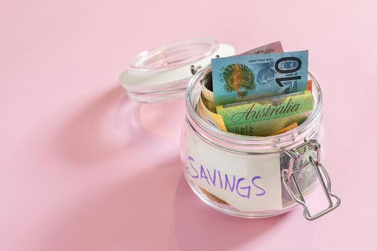Australian dollars in a jar with a piece of paper that says savings