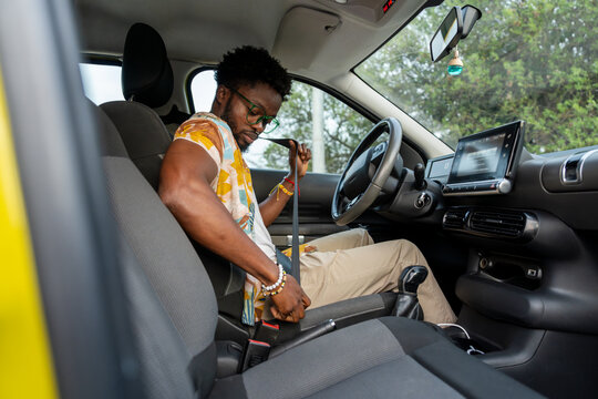 Man putting on seat belt in the car