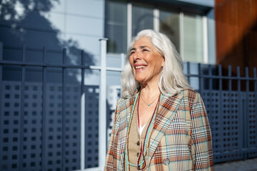 portrait of mature white-haired woman smiling on the street