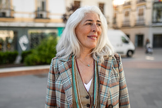 portrait of mature white-haired woman smiling on the street