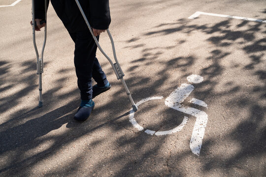 Anonymous Person Using Crutches Outdoors