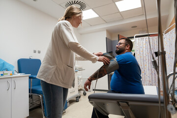 Caring nurse assisting patient in clinic room