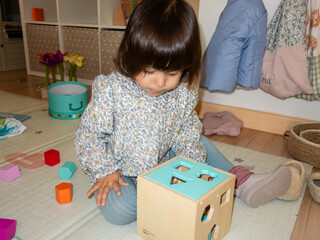 Child playing with shape sorter toy at home