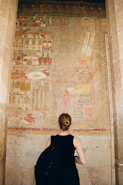 Tourist Exploring Ancient Egyptian Temple Hieroglyphs