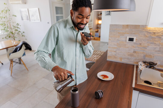 Man talking on cellphone and preparing coffee at home