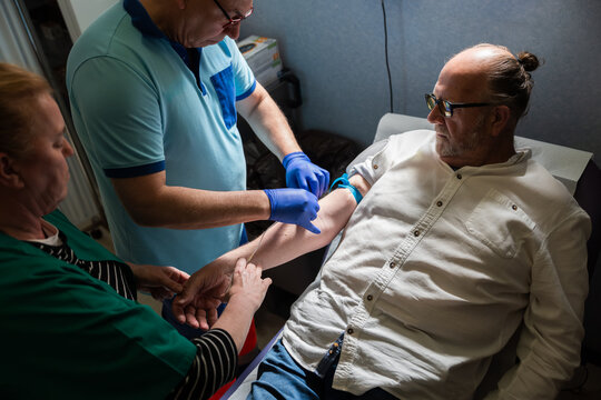 Healthcare professional taking blood sample from patient