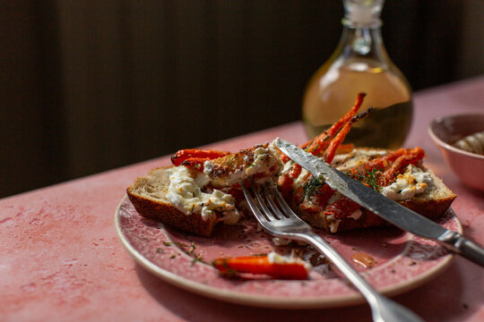 A pink plate with toast and vegatables