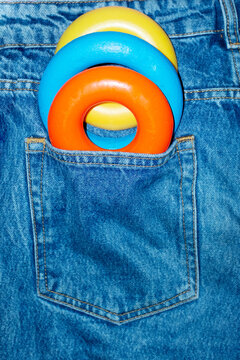 Color geometric shape torus in denim jeans pocket with hard flashlight