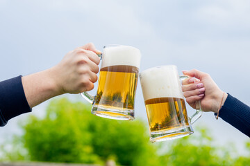 Man and woman clinking beer glasses with beer glasses.
