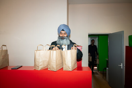 Indian Restaurant Owner Checking Take Away Orders 