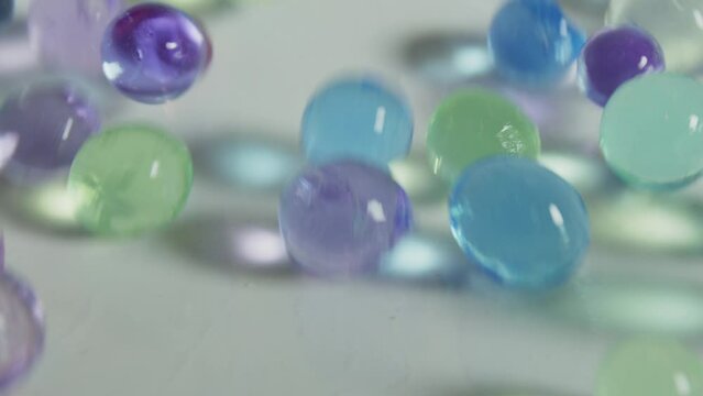 A bunch of colorful glass beads are scattered on a white surface