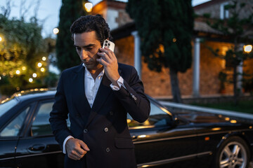 elegant young man in suit jacket using mobile phone